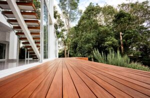 This image depicts wood decking on the side of a house. There are trees on the side of the home.