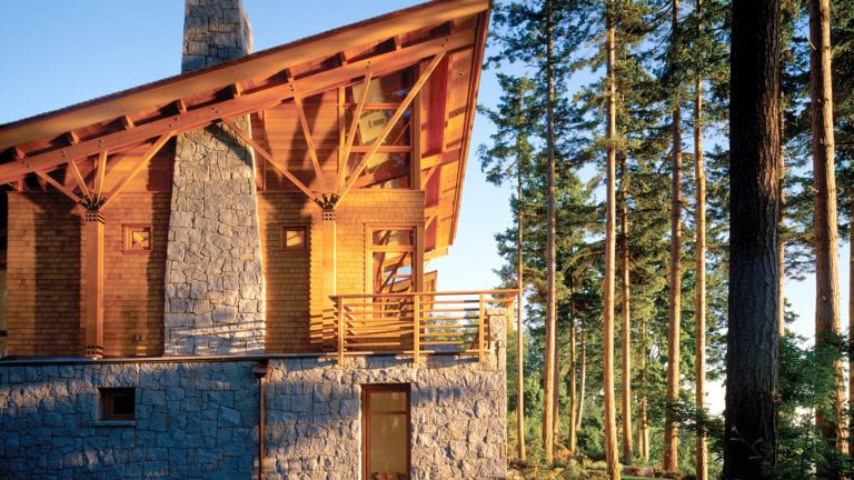 A large wooden home with a stone base surrounded by tees