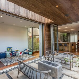 This image depicts an indoor-outdoor eating area with a stone firepit outside and a bar area on the inside. 