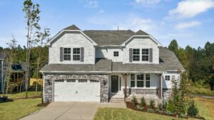 This two-story home features wood columns on the front porch with a metal railing system. 